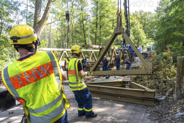 Construction of a temporary bridge over a slipped road crossing a stream, by the bridge