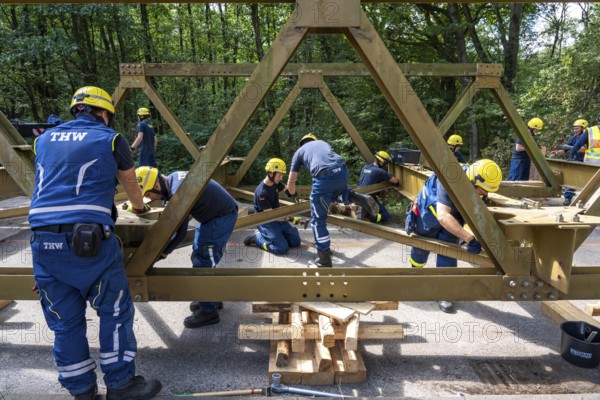 Construction of a temporary bridge over a slipped road crossing a stream, by the bridge