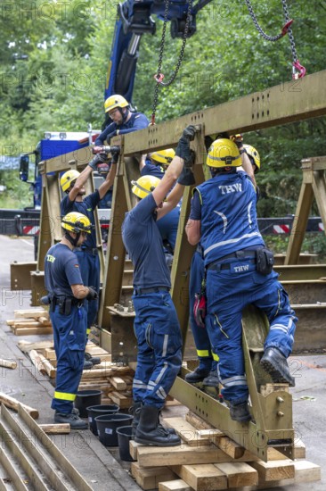 Construction of a temporary bridge over a slipped road crossing a stream, by the bridge