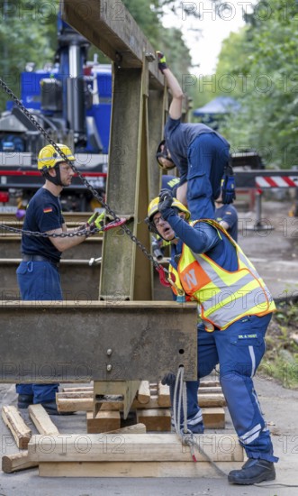 Construction of a temporary bridge over a slipped road crossing a stream, by the bridge