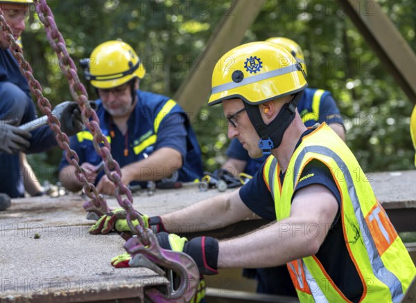 Construction of a temporary bridge over a slipped road crossing a stream, by the bridge