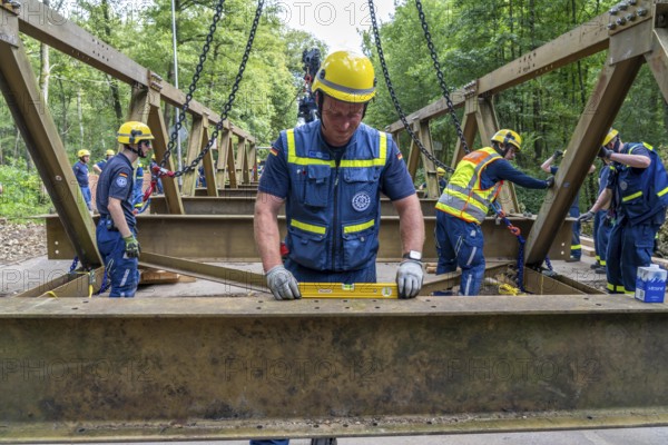 Construction of a temporary bridge over a slipped road crossing a stream, by the bridge