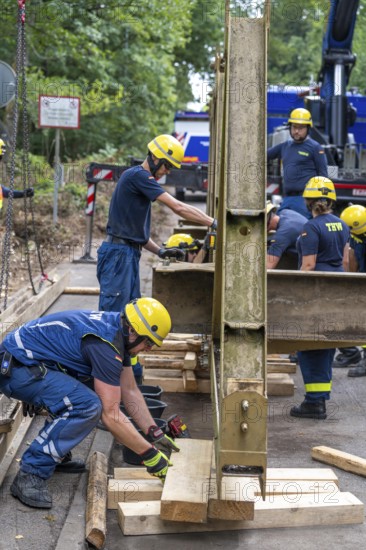 Construction of a temporary bridge over a slipped road crossing a stream, by the bridge