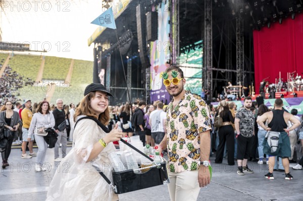 Man in pineapple sunglasses and pineapple shirt with female drinks vendor at Superbloom Festival,