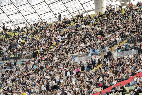 Festival visitors sitting in the stands in the Olympic Stadium at the Superbloom Festival, Day 1 in
