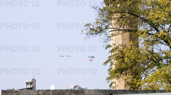 Türkiye special operations police hang from a helicopter with ropes, carrying weapons and unfurling