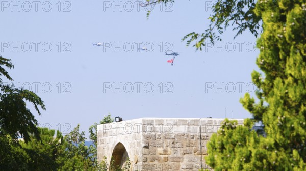 Türkiye special operations police hang from a helicopter with ropes, carrying weapons and unfurling