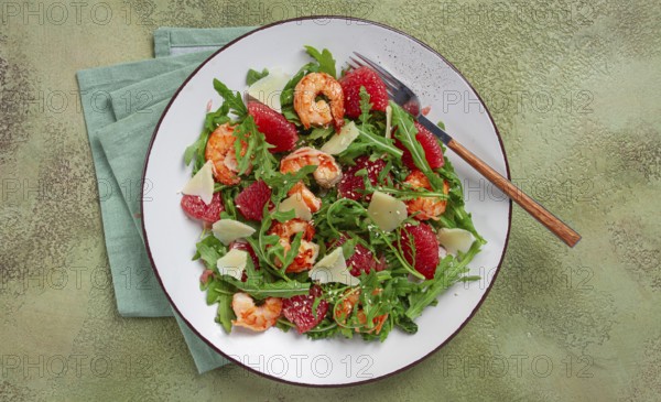 Fresh shrimp salad with arugula, grapefruit, and parmesan served in a bowl
