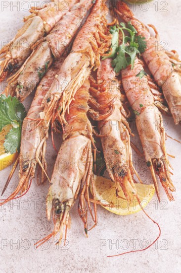 Shrimps on skewers, Grilled, spread on a marble surface, garnished, with lemon slices, and fresh