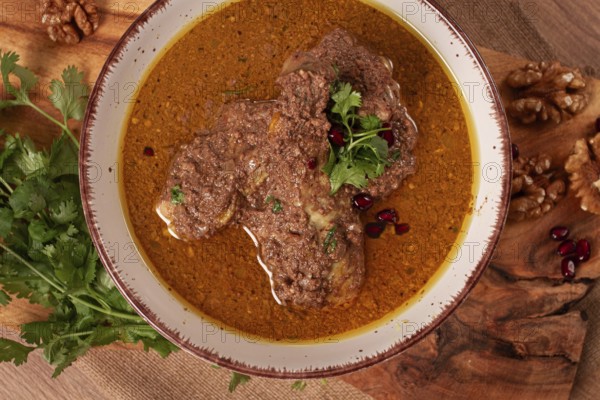 Fesenjan, an Iranian dish, stewed chicken, in a nut-pomegranate sauce, in a bowl, homemade, no