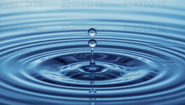 A close-up shot captures the graceful descent of water drops, creating ripples and a mesmerizing