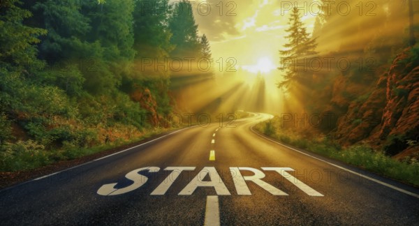 An open road with the word 'start' painted on it, illuminated by sunlight and surrounded by green