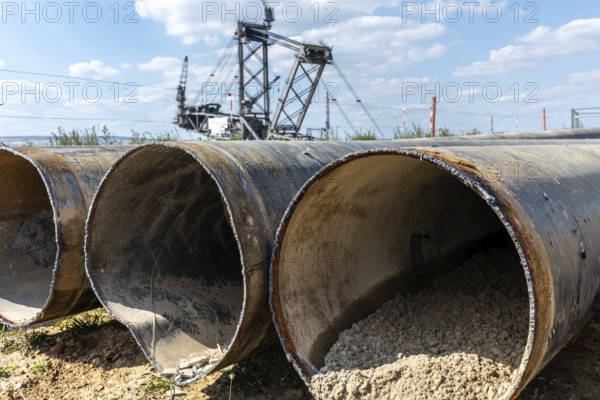 Large excavator in open-cast mine with pipes in the foreground, Manheim, North Rhine-Westphalia,