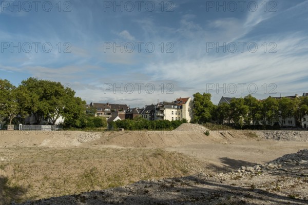 Excavation pit with houses in the background, Ehrenfeld, Cologne, North Rhine-Westphalia, Germany