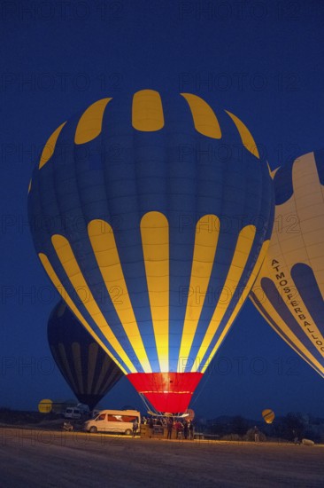 Various hot air balloons are prepared at night and light up the landscape, Göreme National Park,