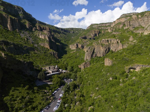 Valley with dense forest and a road leading through the scenery, aerial view, Geghard Monastery,