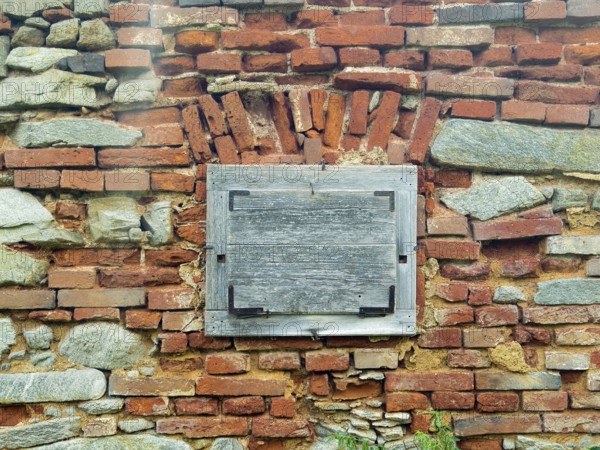 Brick wall with closed wooden window, aged and with a rough texture Styria Austria