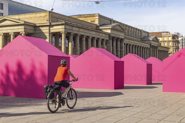 Twelve houses in bright magenta stand on Stuttgart's Schlossplatz in front of the art museum. The