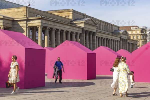 Twelve houses in bright magenta stand on Stuttgart's Schlossplatz in front of the art museum. The