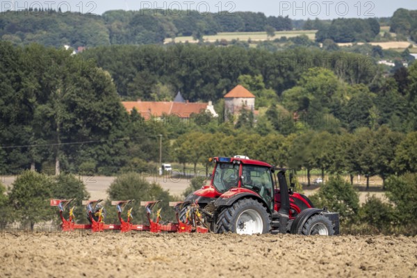 Tractor ploughs up a harvested grain field, south of Billerbeck in Münsterland, North