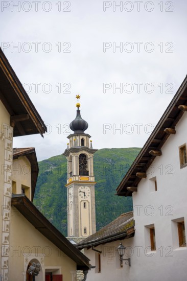 Beautiful Street in Old Town with Mountain View and Church Tower in a Summer Day in Samedan,