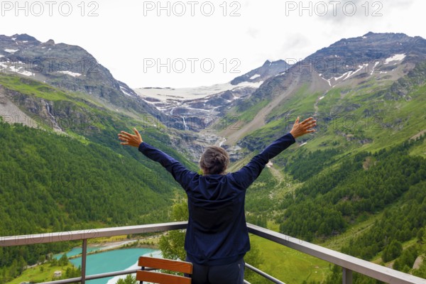 Woman with Arms Outstretched over the Beautiful Mountain Alp Grüm with Glacier and Alpine Lake Palü