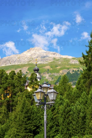 Church Tower and Street Lamp in the Forest and Mountain in the Swiss Alps in a Sunny Summer Day in