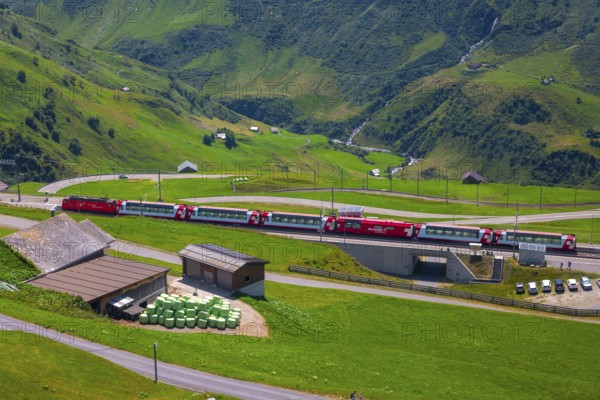 Beautiful View over Mountain Valley with Mountain Road and Railroad Station with Glacier Express