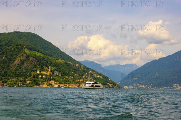 Passenger Ship on Lake Lugano and House and Church on Mountain Range in a Sunny Summer Day on the