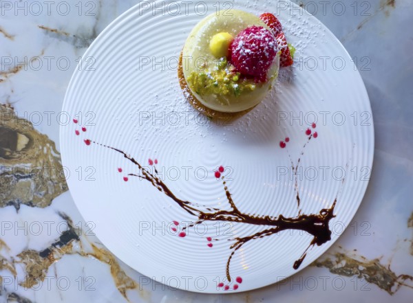 Elegant Dessert Creamy Pistachio Biscuit with Fresh Cream and Decorated with Raspberry and Chopped