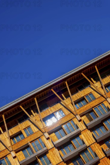 Beautiful Modern Wood Facade Building with Balcony Against Blue Clear Sky in a Sunny Summer Day in