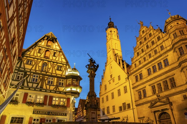 Georgsbrunnen, Marien-Apotheke, town hall and town hall tower in Rothenburg ob der Tauber at dusk,