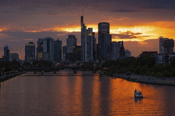 The sun breaks through the clouds behind the Frankfurt banking skyline shortly in front of setting,