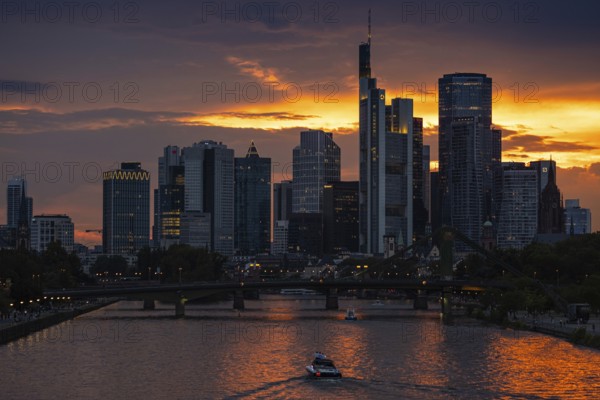 The sun breaks through the clouds behind the Frankfurt banking skyline shortly in front of setting,