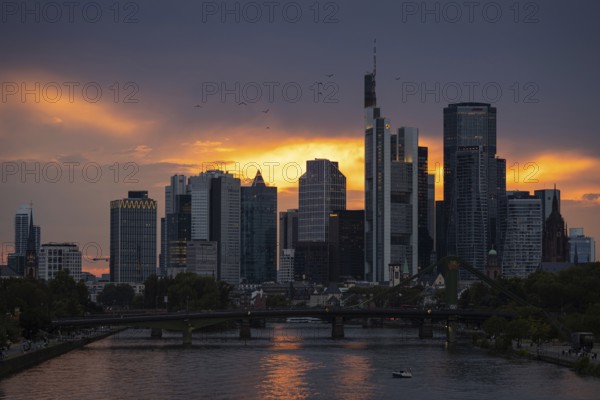 The sun breaks through the clouds behind the Frankfurt banking skyline shortly in front of setting,