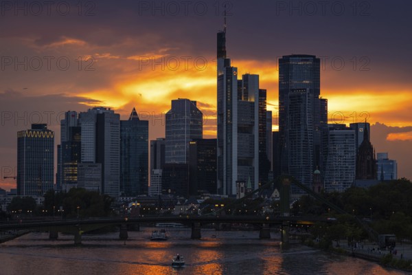The sun breaks through the clouds behind the Frankfurt banking skyline shortly in front of setting,