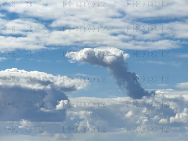 Cumulonimbus cluster cloud towering in the centre of the image, Altostratus above, Stratocumuus