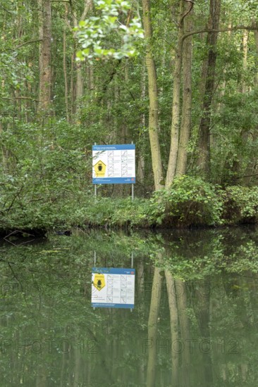 Entrance to the national park, information sign, trees, reflection, canal Alte Fahrt between Bolter