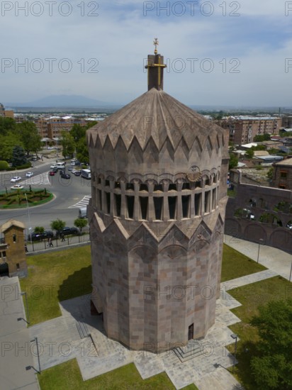 Distinctive stone tower in an urban setting under a blue sky, aerial view, Holy Archangel Church,