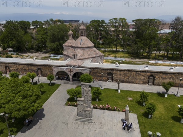 Historic church and monument in a green park with people in an urban setting, aerial view, St