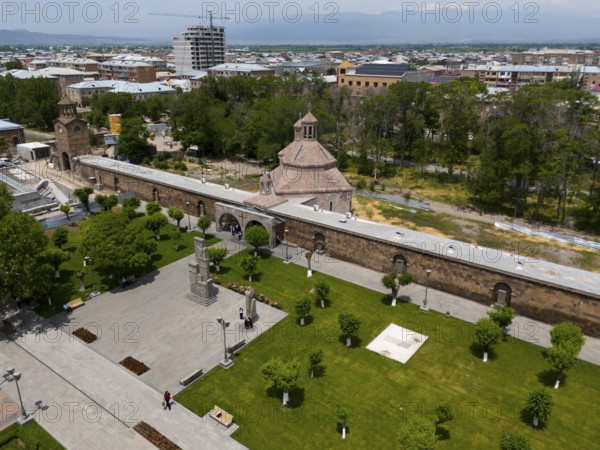 Historical monastery complex in the middle of a green park with city view and mountains in the
