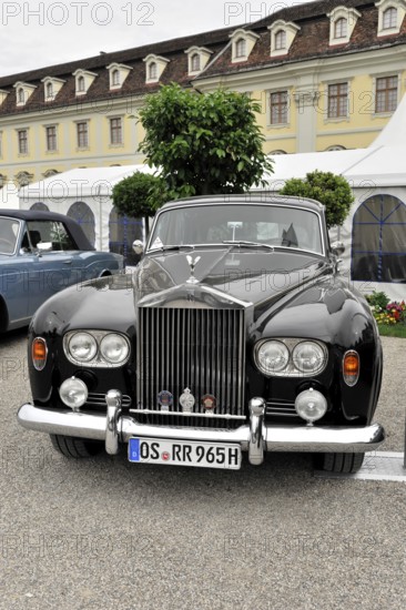 A black classic Rolls-Royce vintage car parked in front of a historic building, Retro Classics
