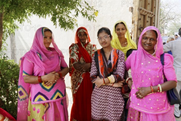 Kota, Rajasthan, North India, Asia, Group of woman in traditional dress standing under a tree,