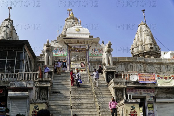 Entrance to Jagdish Temple, Udaipur, People climb the steps to a temple flanked by statues under a
