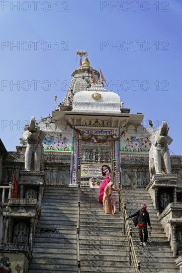 Entrance to Jagdish Temple, Udaipur, People climb the steps to a temple flanked by statues under a