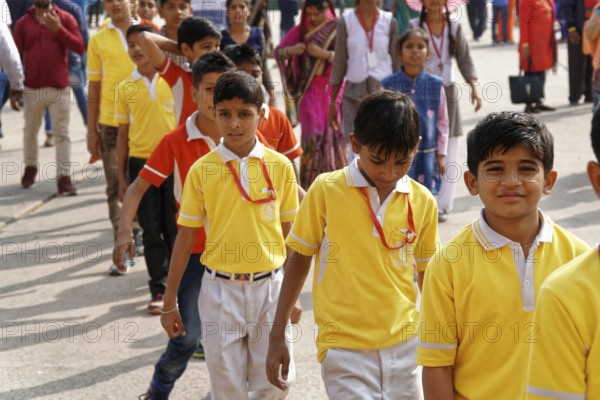 Group of children in yellow school uniforms standing happily in a row, Agra, Jodhpur, Rajasthan,