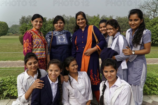 Group of female teachers and students in colourful clothes posing smiling outdoors, Agra, Jodhpur,