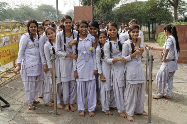 Girls in uniforms stand close together behind a protective fence, Agra, Jodhpur, Rajasthan, North
