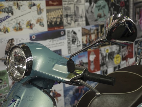 Retro scooter in blue with a chrome mirror, surrounded by billboards in the background, dortmund,