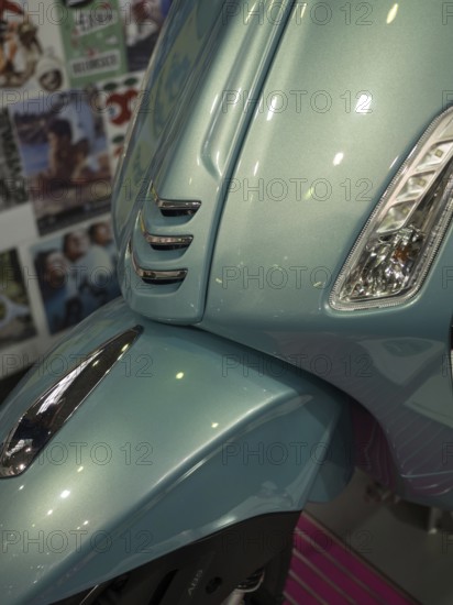 Front of a blue scooter in retro style with glossy paint and shiny chrome details, dortmund,